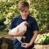 Young boy holding white chicken